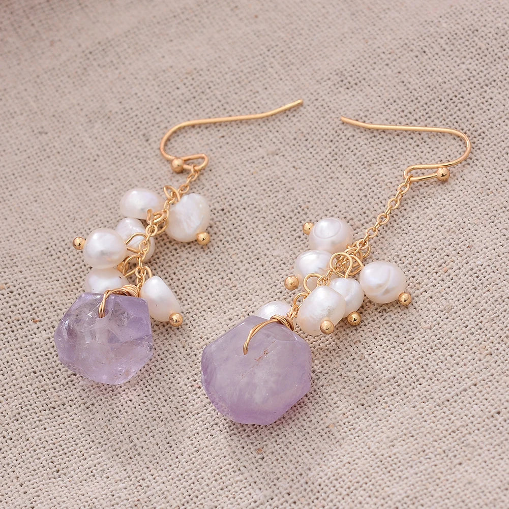 Twilight Bloom Earrings laid flat on textured fabric, showcasing the organic charm of amethyst and freshwater pearls.