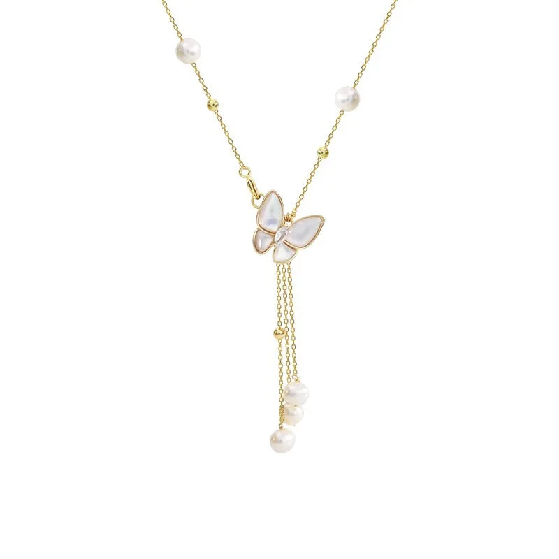 Studio shot of Wings of Love Necklace with butterfly charm and freshwater pearls on gold chain, perfect for feminine and elegant styling.