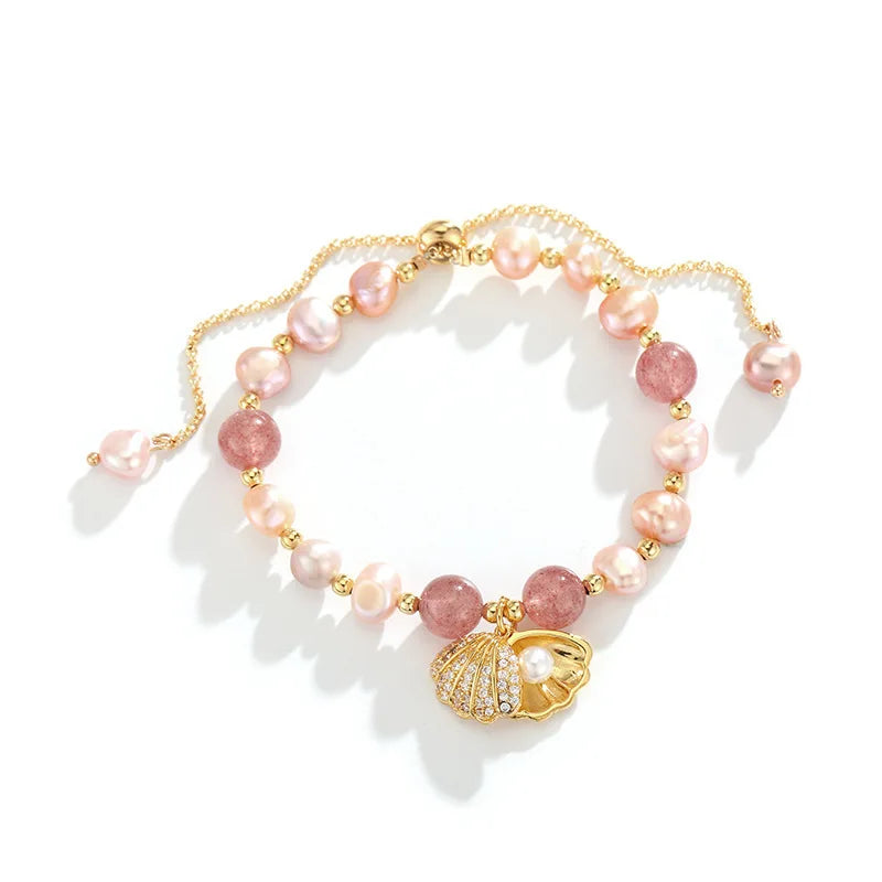 Top view of Pink Whisper Shell Bracelet featuring a mix of pink pearls, quartz stones, and a gold shell charm centerpiece.