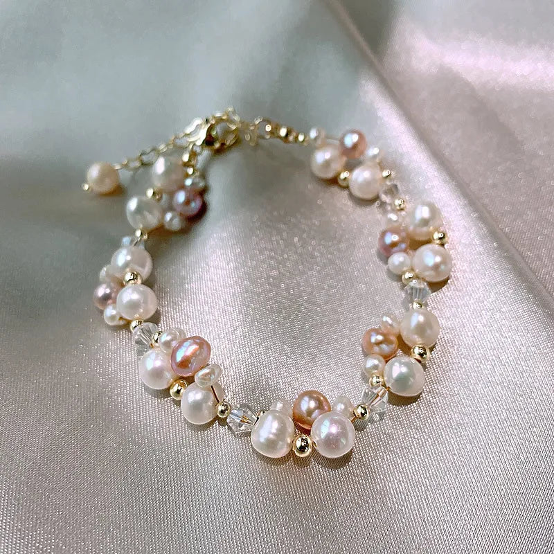 Luminous Dreams Set bracelet with multicolored pearls and gold-filled beads, resting on a shimmering satin background.