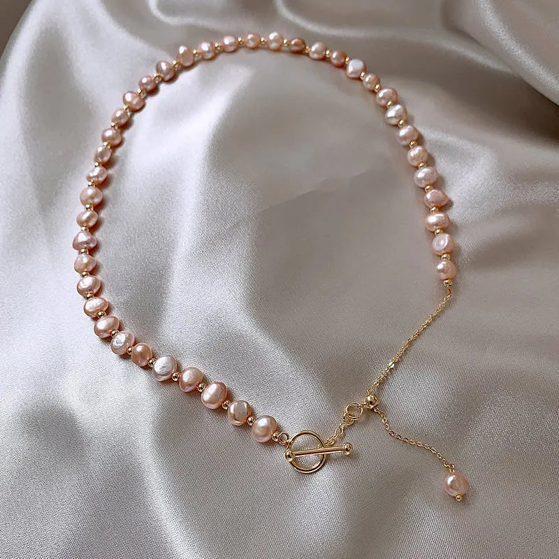 Natural Pink Baroque Pearl Gold-Filled Necklace with toggle clasp and drop pearl charm, arranged on soft satin fabric.
