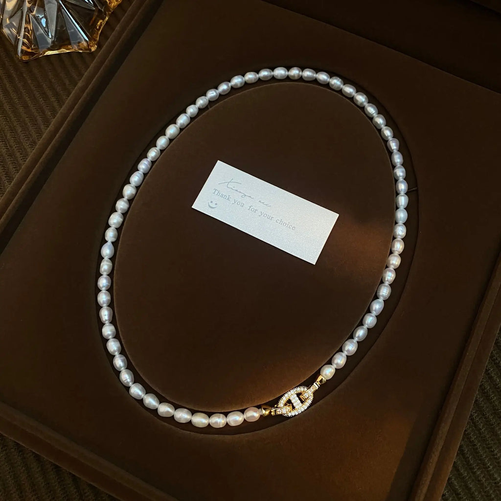 Heavenly Glow Choker with white pearls and a gold cross clasp, elegantly placed in a premium gift box with a thank-you card.