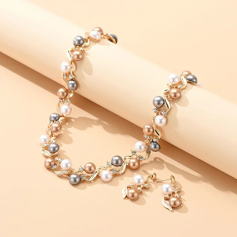 Royal Serenity Set for Women laid out on a soft peach background, showcasing the necklace and earrings with elegant pearl clusters.