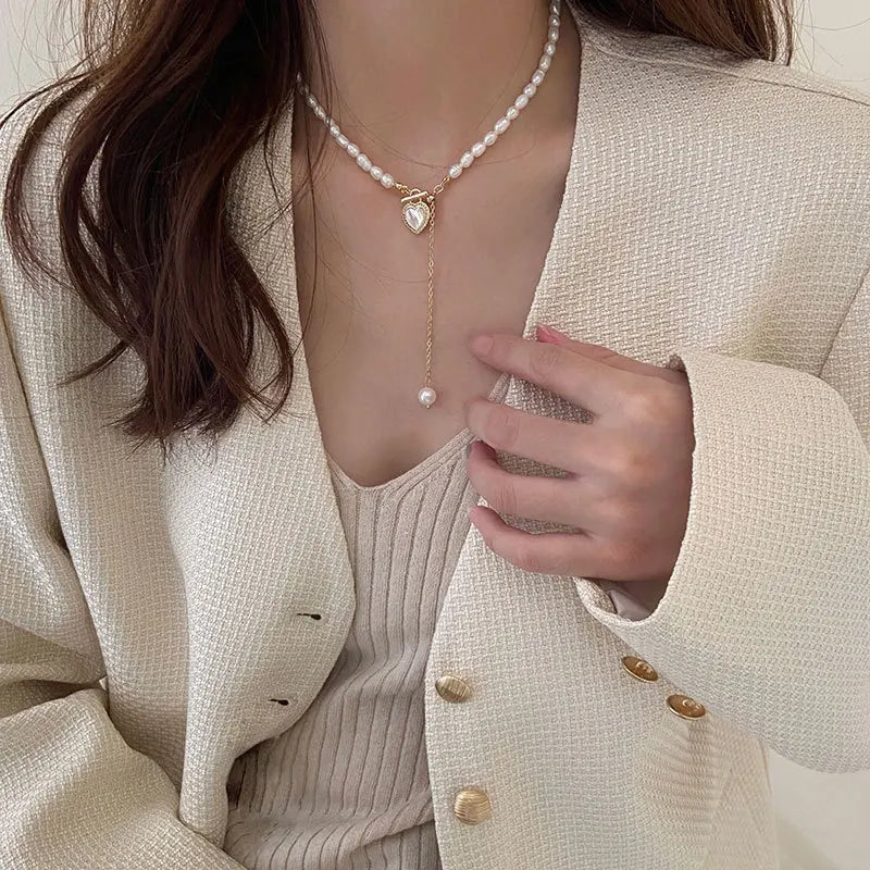 Model wearing Pearl of My Heart Necklace with a cream blazer, showcasing its timeless elegance and romantic heart charm design.