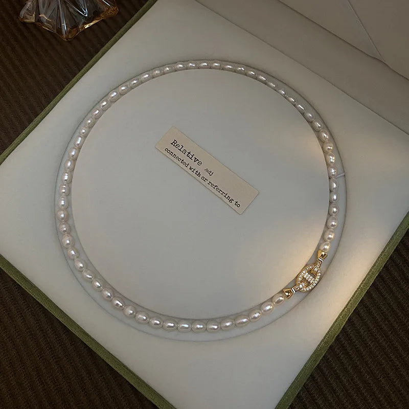 Elegant Heavenly Glow Choker featuring lustrous freshwater pearls and a gold crystal cross clasp, presented in a luxury jewelry box.